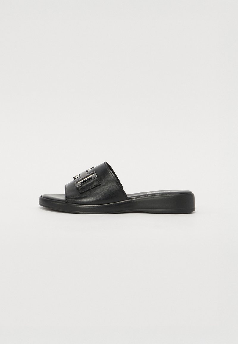 Sandale mule en cuir noir avec un petit talon compensé et un détail de boucle argentée sur la sangle large.