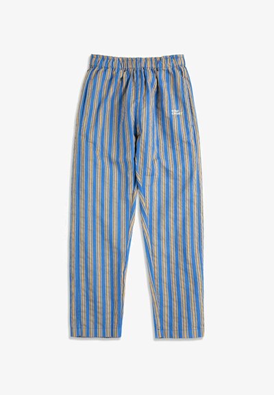 Pantalon ample à rayures verticales bleu et beige, taille élastique, poches latérales, et petit logo blanc sur le haut à droite devant.