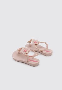Las chanclas de plástico rosa presentan dos grandes adornos florales y pequeñas perlas en las correas, con una plantilla texturizada y una suela suave.