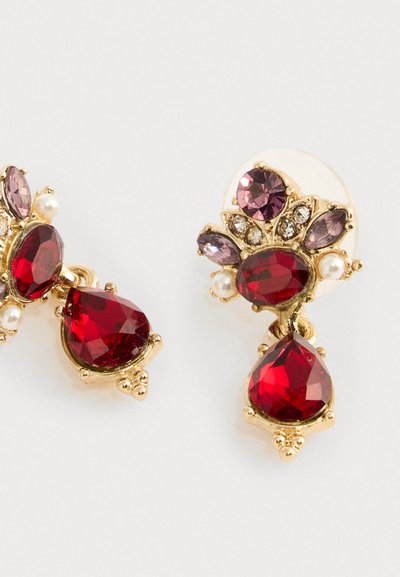 Gold earrings with large red teardrop and oval gems, smaller purple stones, white pearls, and clear crystals arranged in a floral design.