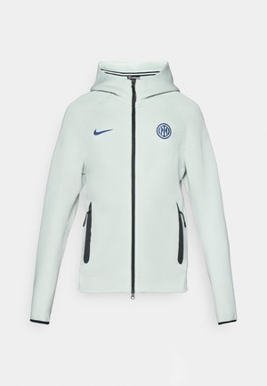 Ανοιχτό πράσινο σακάκι Nike με κλείσιμο φερμουάρ, капюшон και μαύρες λεπτομέρειες. Διαθέτει πλαϊνές τσέπες με φερμουάρ και κεντητό λογότυπο στο στήθος.