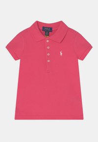 Różowa koszulka polo z krótkimi rękawami, trzema guzikami na plisce oraz białym haftowanym logo na lewej piersi. Wykonana z bawełnianego materiału o fakturze.