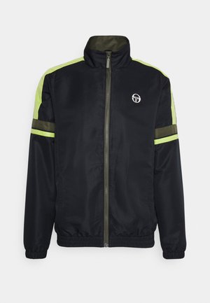 Mustassa tuulitakissa on korkea kaulus, vihreät korostusraidat harteilla ja hihoissa, joustavat hihansuut sekä logo rinnassa.