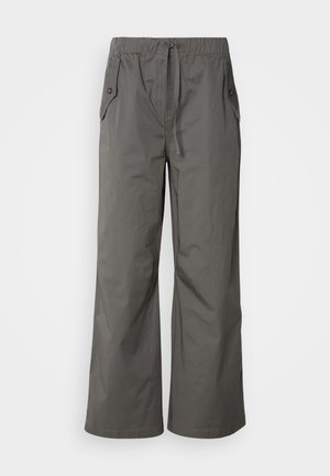 Pantaloni larghi grigi realizzati in tessuto leggero, con cintura elastica, coulisse e due tasche laterali con dettagli in bottone.
