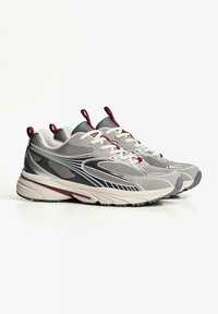 Gray athletic shoes with mesh and synthetic upper, white laces, red accents, padded collar, and a textured rubber outsole.