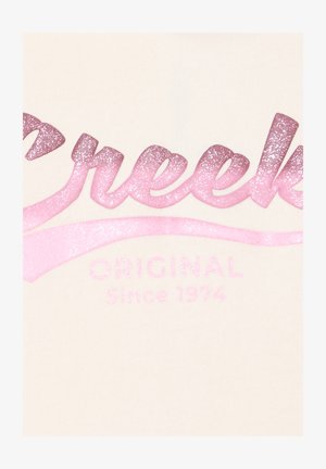 Tela color crema con un texto en degradado brillante en rosa, que presenta "Creek" y "Original desde 1974" en un acabado brillante.