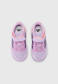 Baskets de sport violettes avec une tige en mesh respirant et des lacets élastiques. Comprend une sangle Velcro et une semelle texturée pour une bonne adhérence.