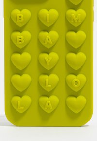 Funda de teléfono de silicona amarilla con formas de corazones en relieve y letras "B", "I", "M", "Y", "L", "A". Superficie texturizada, bordes redondeados.