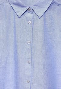 Camicia button-up azzurrina con colletto, realizzata in un tessuto testurizzato e con cinque piccoli bottoni tondi sulla parte anteriore.