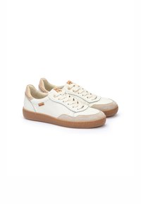 Zapatillas de piel blanca con detalles de ante beige y suelas de goma beige. Presentan punteras redondeadas, diseño de cordones y detalles de logotipo sutiles.