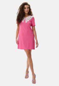 Pink short-sleeve dress with a lace collar, A-line design, smooth fabric, and matching purple strappy sandals.