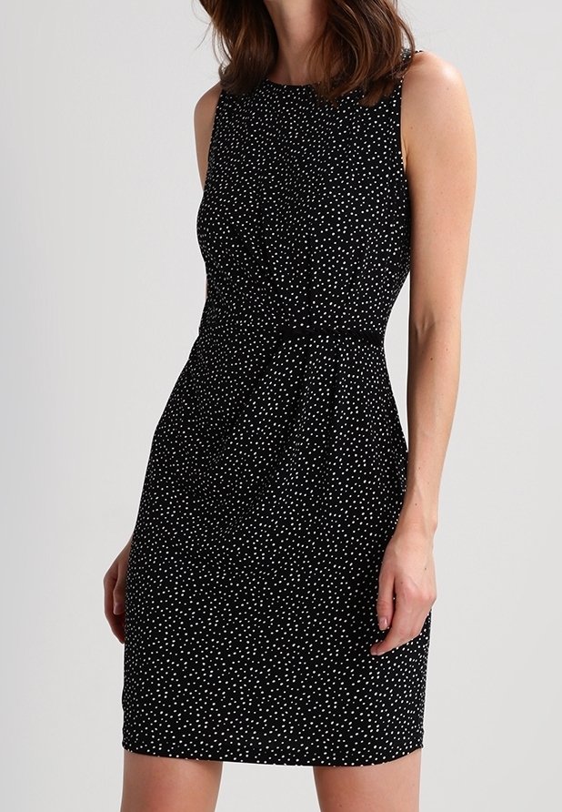 Black sleeveless dress with white polka dots, fitted waist, and knee-length design. Smooth texture and subtle gathering at waist create shape.