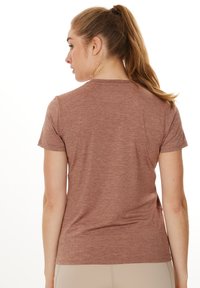 T-shirt à manches courtes, col ras du cou, dans une teinte rouge-brun atténuée, fabriqué dans un tissu doux et texturé avec un léger motif chiné.