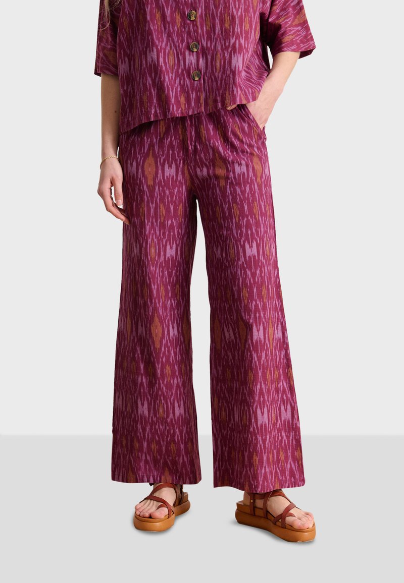 Fuchsia wijde broek met een ikatpatroon in tinten roze en oranje, vervaardigd uit een lichte stof met een ontspannen pasvorm.