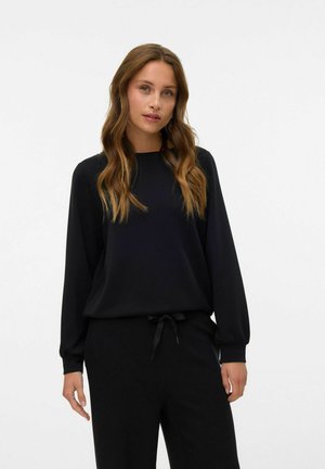 Zwarte langemouwen top met een ronde halslijn en een relaxte pasvorm. Gemaakt van zachte stof en met een geknoopte accent aan de taille, gecombineerd met bijpassende zwarte broek.