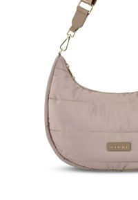 Gep quiltete, hellbeige Schultertasche mit einer geschwungenen Form. Verfügt über einen Reißverschlussverschluss und einen strukturierten Tragegurt mit goldenen Hardwareakzenten.