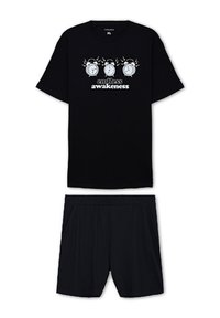 T-shirt nera a maniche corte con una grafica bianca raffigurante orologi e la frase "svegliarsi senza fine". Abbinata a pantaloni corti neri coordinati.