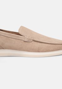 Beige suede instapschoenen met een gladde textuur, ronde neus en minimale stikselaccenten; voorzien van een flexibele, lichtgekleurde zool.