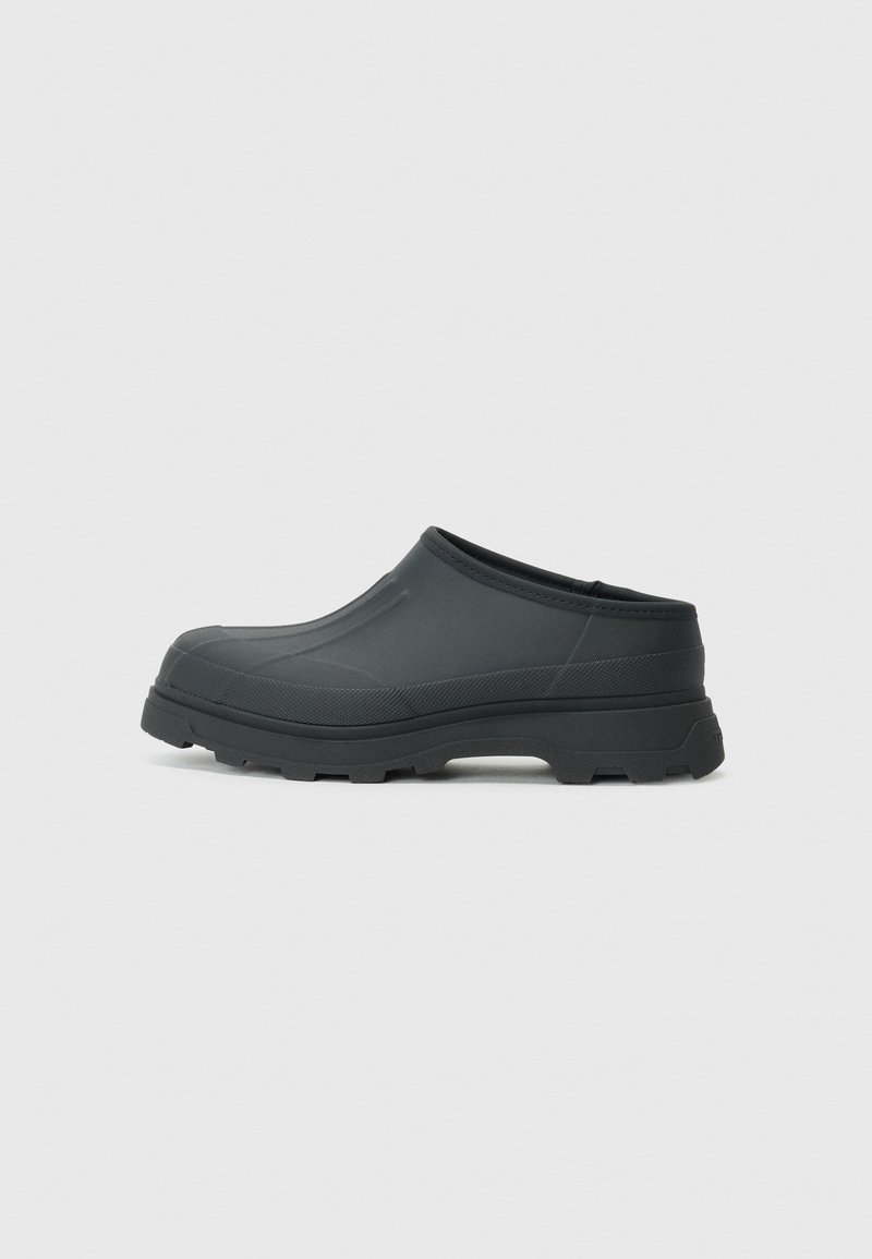 Black slip-on clog made of rubber-like material. Features a textured surface and a rugged sole for traction. Rounded toe design.