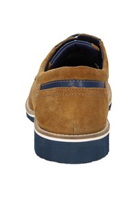 Chaussure en daim marron avec un accent en cuir bleu marine au talon, coutures blanches et semelle en caoutchouc nervurée. Vue arrière montrant le design et la texture.