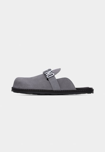 Sabot en daim gris à enfiler, dos ouvert et bride supérieure avec lettrage "UNO" en noir et blanc, semelle noire sur fond blanc.