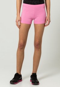 Różowe sportowe spodenki wykonane z elastycznego materiału o dopasowanym kroju. Posiadają wysoką talię i minimalne oznaczenia na pasku.