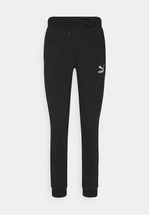 Pantalons de survêtement noirs en coton avec une taille à cordon, des poignets ajustés et un logo Puma blanc sur la cuisse gauche. Texture lisse, design fuselé.