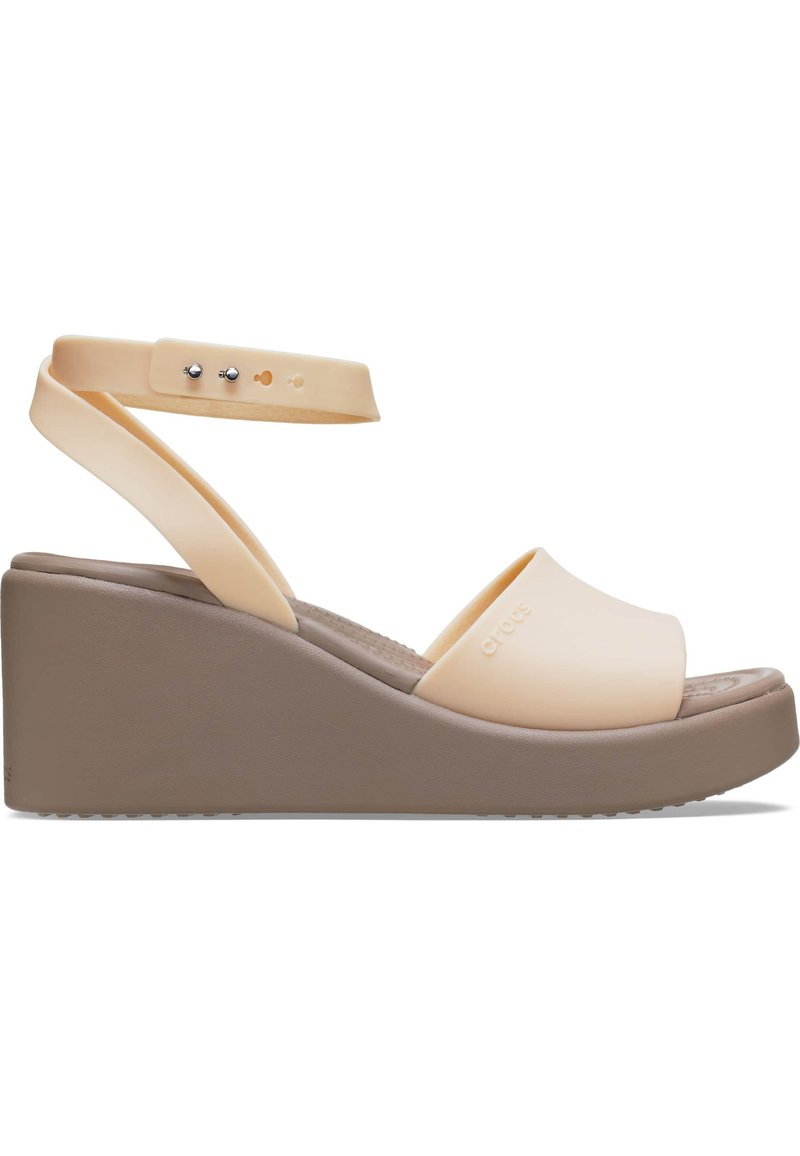 Sandales compensées avec une tige pêche clair, de larges brides, une bride de cheville réglable et une semelle en platforme marron. Semelle intérieure texturée pour le confort.