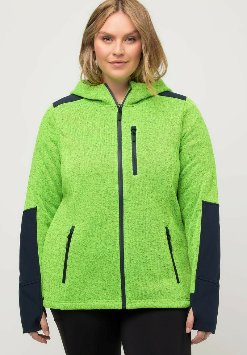 Giacca in pile verde con cappuccio, accenti in un contrastante blu navy scuro, tasche con zip e una finitura testurizzata. Presenta una chiusura con zip frontale.