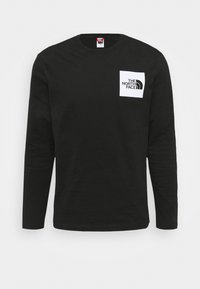 Svart långärmad t-shirt i bomull med rund hals. Har en vit fyrkantig logotyp på bröstet med texten "The North Face".