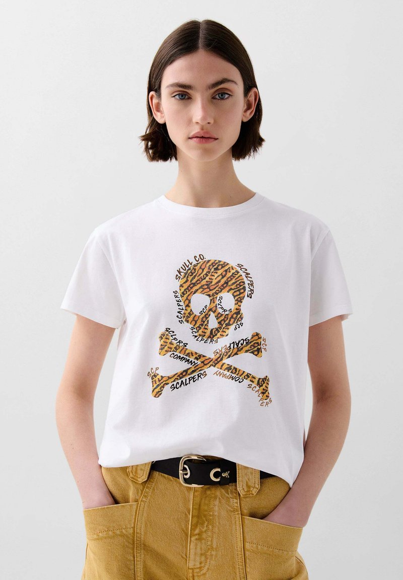 Witte katoenen T-shirt met een gestructureerd leopardenprint schedel-en-kruisbones ontwerp, met herhaalde tekstelementen in het zwart. Met een ceintuur in de taille.