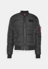Čierna vystužená bomber bunda, s predným zipsom, rebrovanými manžetami a lemom a logom na hrudi. Hladká látka s prešívanou textúrou.