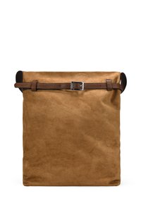 Bolso de gamuza marrón con parte superior enrollada, asegurada por una correa de cuero marrón y un hebilla de metal. Presenta una textura suave y mate, y tiene una forma vertical.