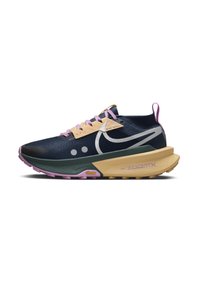 Zapatilla de trail running de Nike con una parte superior en color azul marino, acentos en marrón claro, cordones morados y una suela gruesa con una base en color rosa y beige.