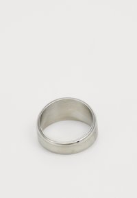 Bague en métal argenté avec une finition lisse et mate et un extérieur légèrement arrondi. L'intérieur présente un détail de rainure subtil.