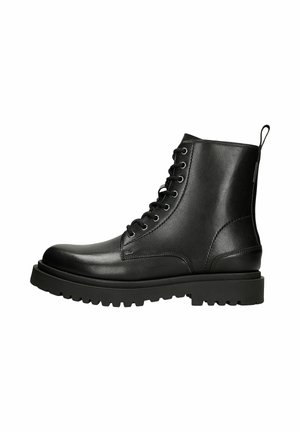 Bottines à lacets noires avec un dessus en cuir verni, semelle en caoutchouc robuste et une languette à l'arrière pour un enfilage facile.