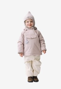 Lyserød vandtæt jakke med lomme foran og stjerneaccent, sat sammen med hvide isolerede bukser og brune støvler. Strikket hat med spids top.