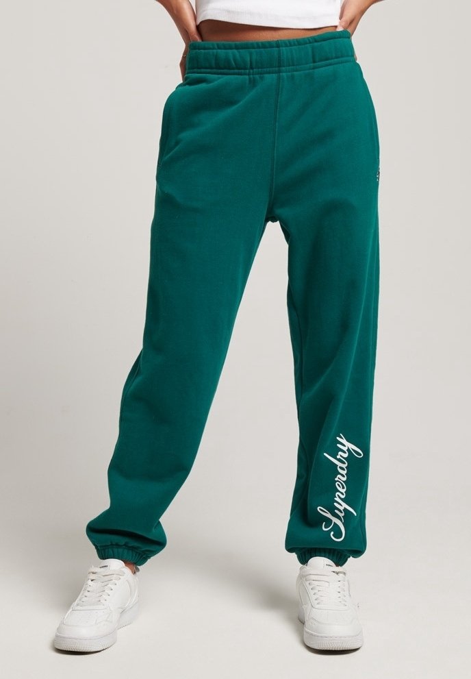 Türkise Sweatpants mit schmalem Schnitt, ausgestattet mit einem elastischen Bund und Bündchen. "Superdry"-Logo in Weiß auf dem linken Bein.