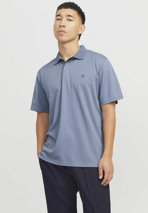 Polo bleu clair avec un col et des manches courtes, arborant un petit logo sur la poitrine. Fabriqué en un matériau lisse et doux.
