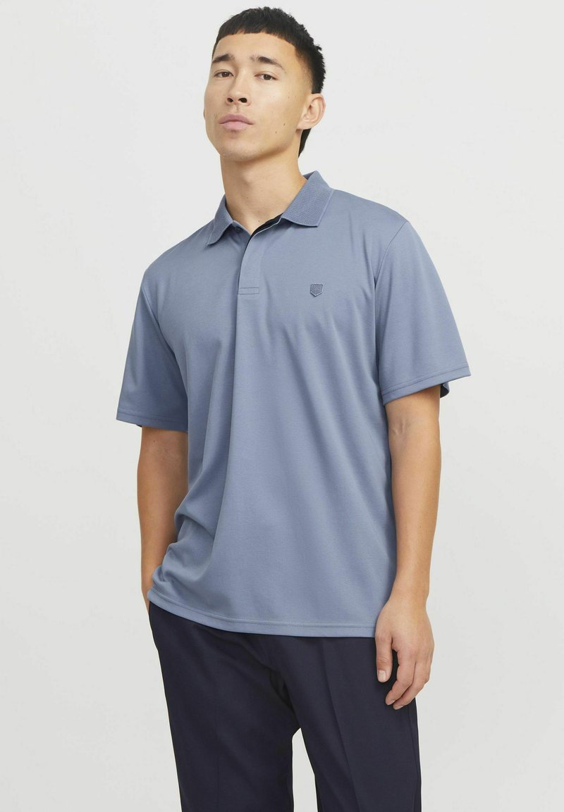 Lichtblauw polo-shirt met een kraag en korte mouwen, voorzien van een klein logo op de borst. Gemaakt van een glad, zacht materiaal.