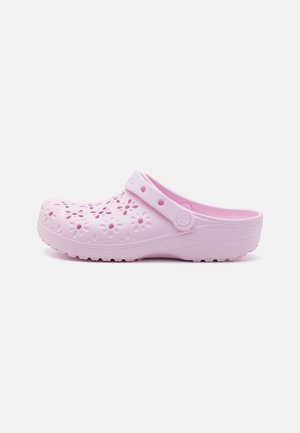 Pink plastic clog with floral cutouts, snug strap, and textured sole. Lightweight design with a smooth finish and rounded toe.