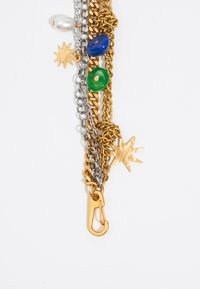 Catene in oro e argento intervallate da perline colorate (verdi, blu) e un dettaglio a forma di stella, con una chiusura in oro per il fissaggio.