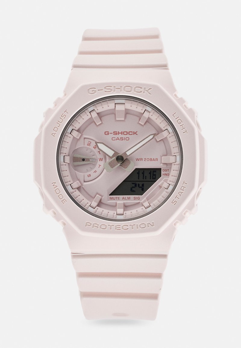 G-SHOCK óra világos rózsaszín műanyag pánttal, kerek számlappal és analóg-digitális kijelzővel. Jellemzői közé tartozik egy textúrázott keret és különböző gombok.