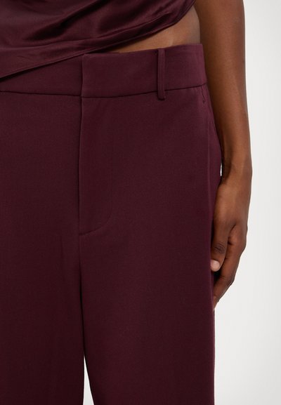 Burgundy byxor med en slät yta, med platt fram, sidofickor och bälteshällor, kompletterat med en åtsittande midja.