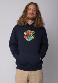 Marineblaue Kapuzenjacke aus Baumwollmischung mit einem zentralen Rubik's Cube Grafik, die lebendige Farben und ein pixeliertes Design zeigt. Mit Kängurutasche.