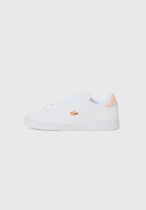Biały niski sneaker z białymi sznurowadłami, beżowym panelem na pięcie i różowo-złotym logo krokodyla Lacoste po boku.