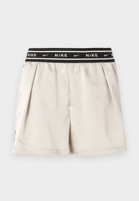 Ανοιχτό μπεζ σορτς Nike με μαύρη ελαστική μέση που διαθέτει λευκό λογότυπο Nike και μοτίβα swoosh, παρουσιάζονται σε απλό φόντο.