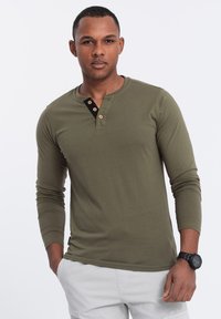Langärmliges Henley-Shirt in olivgrün, mit einer schwarzen Knopfleiste aus Holzknöpfen, aus glattem Baumwollstoff und taillierter Passform.