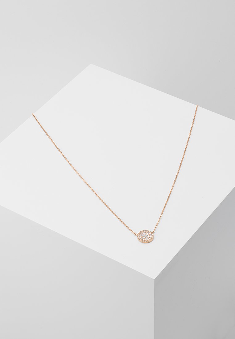 Collana in oro rosa con una delicata catena e pendente circolare che presenta un motivo geometrico. Esposta su un display minimalista.