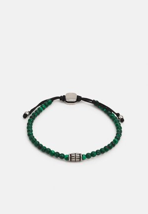 Bracelet en cordon noir ajustable avec des perles rondes vertes et une perle décorative centrale en argent sur fond blanc.